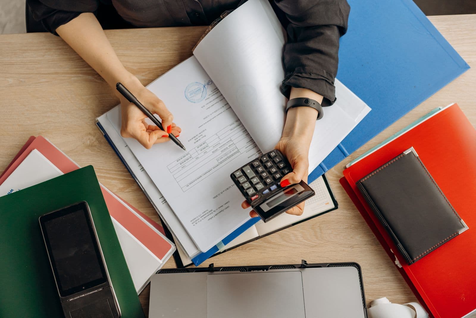 Reviewing financial records with a calculator and pen